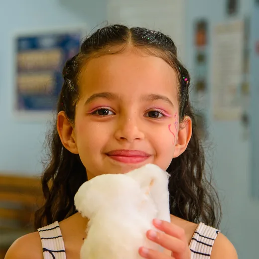 Aluna da CaHsi sorrindo, com algodão-doce na mão